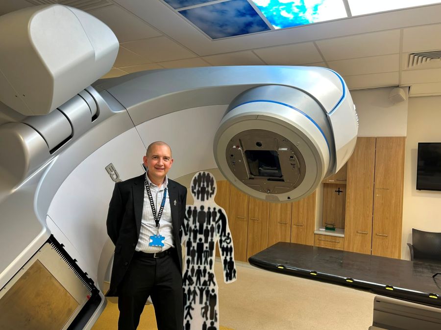 A photo of Kevin smiling while standing in front of medical equipment.