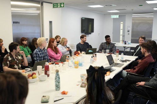 A group of colleagues sitting around a table in discussion.